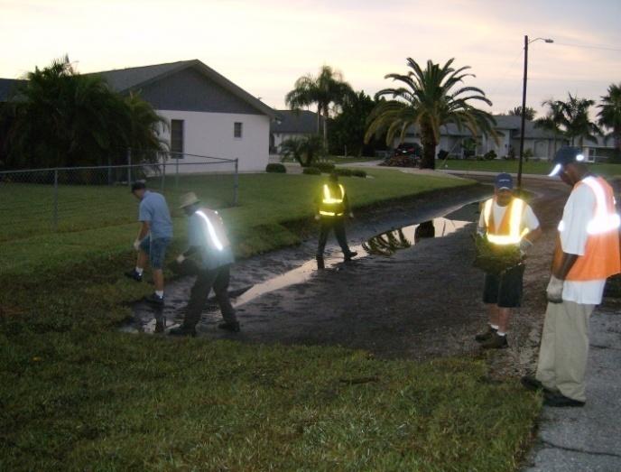 Workers Inspecting Movement of Stormwater in Swale
